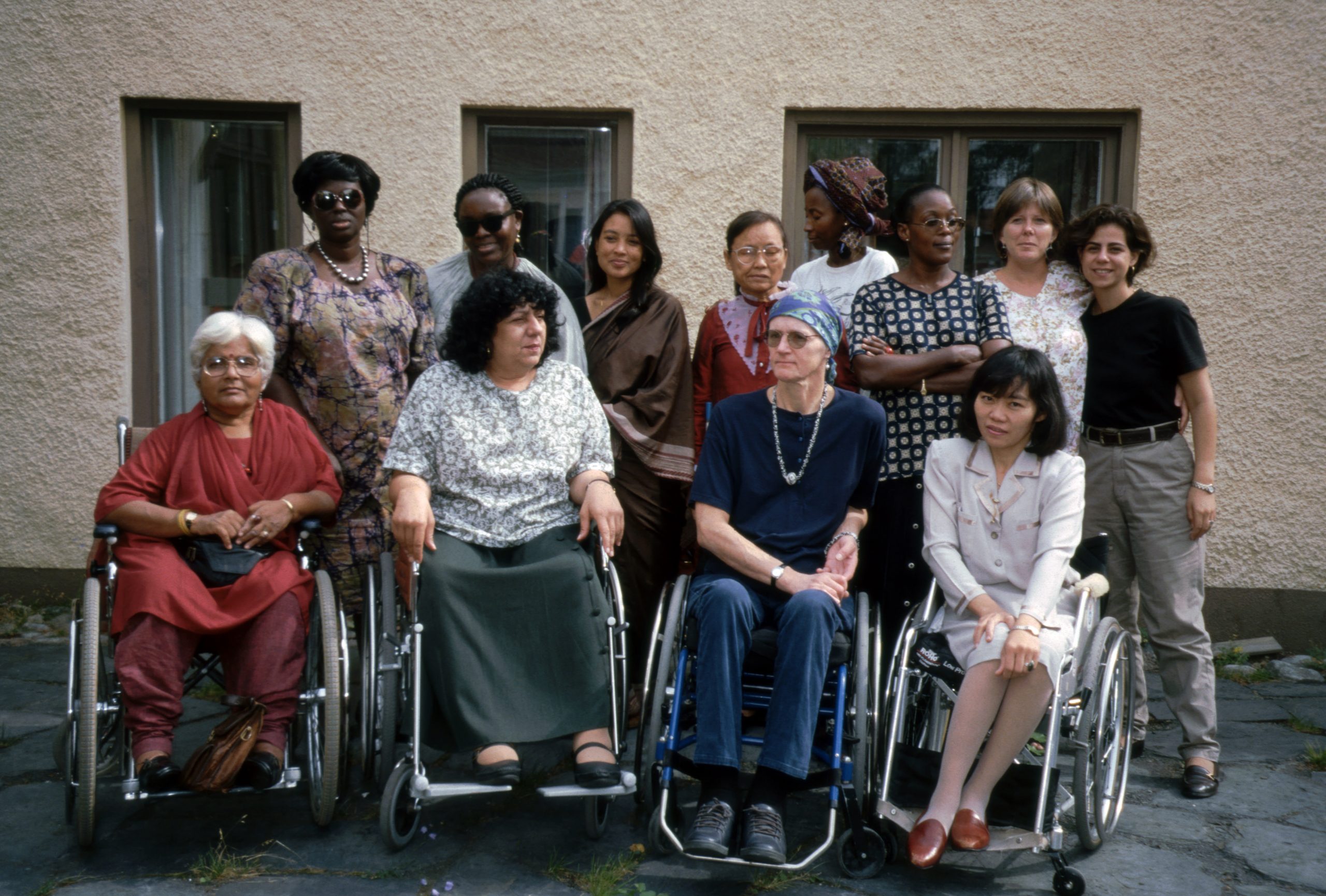 Två rader med personer från olika länder, på första raden sitter fyra personer i rullstol och bakom de står åtta personer. Bild från ett tidigt myright projekt