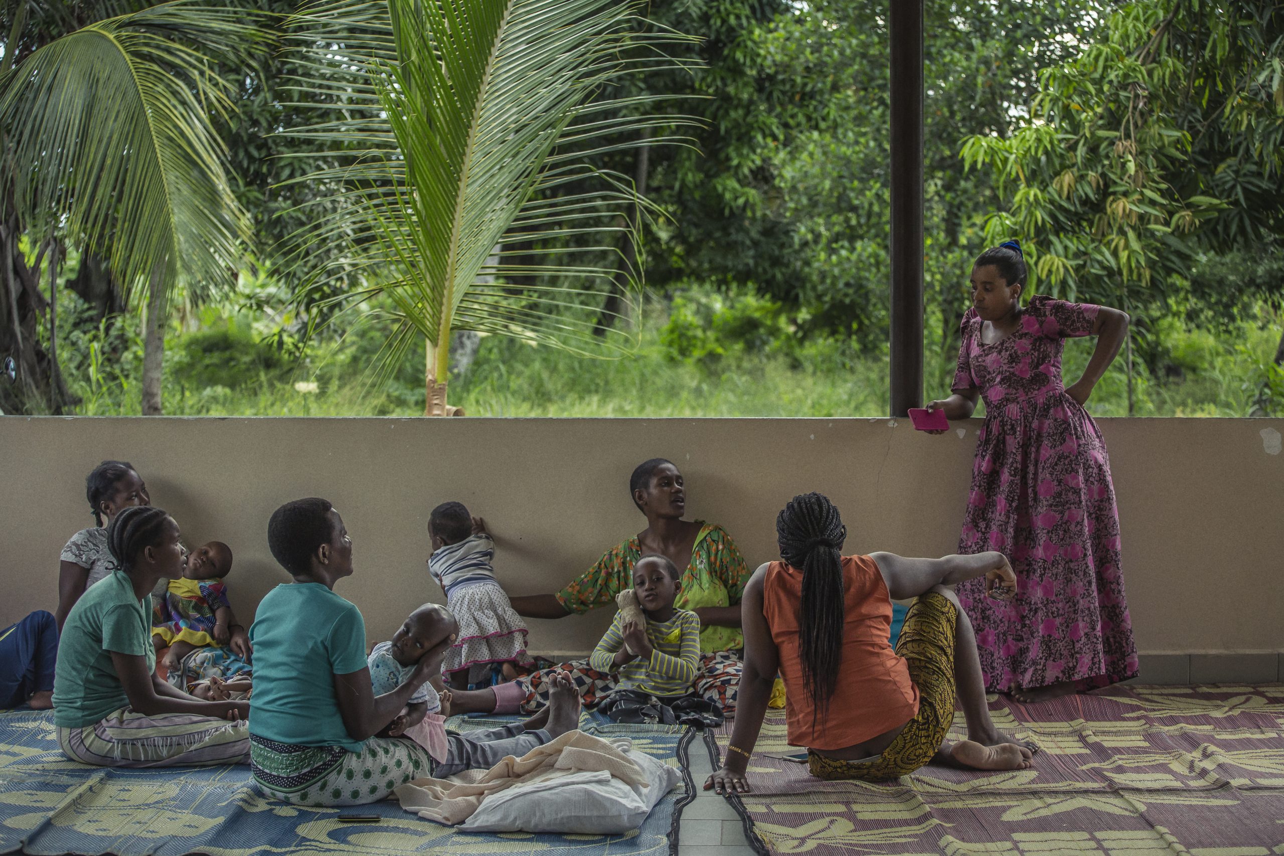 mujeres sentadas con sus hijos en un círculo, Hidaya se para con la mano en la cadera frente a ellas y habla