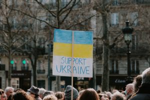 demonstration mot kriget i Ukraina, en person håller en skylt med Ukrainas flagga där det står "support Ukraine"