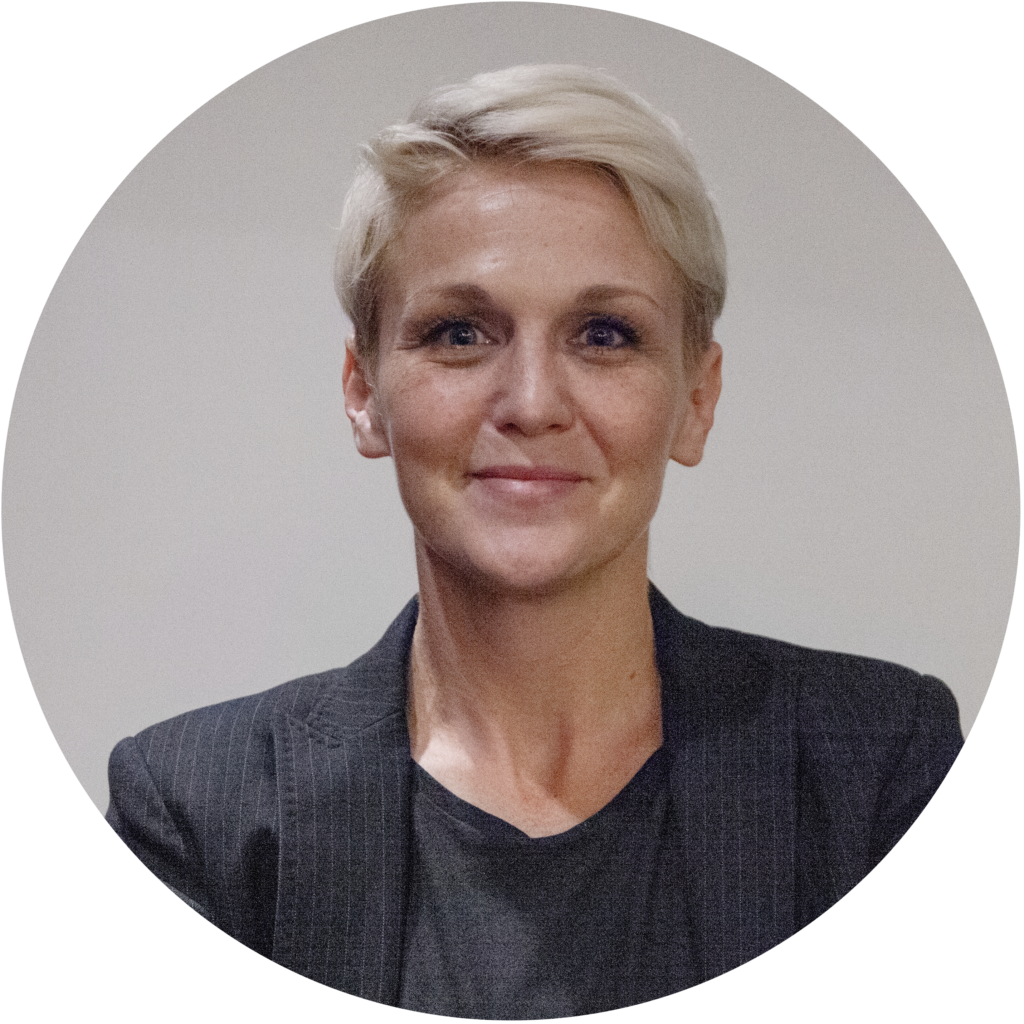 Elvedina har kort ljust hår och en svart kavaj.
